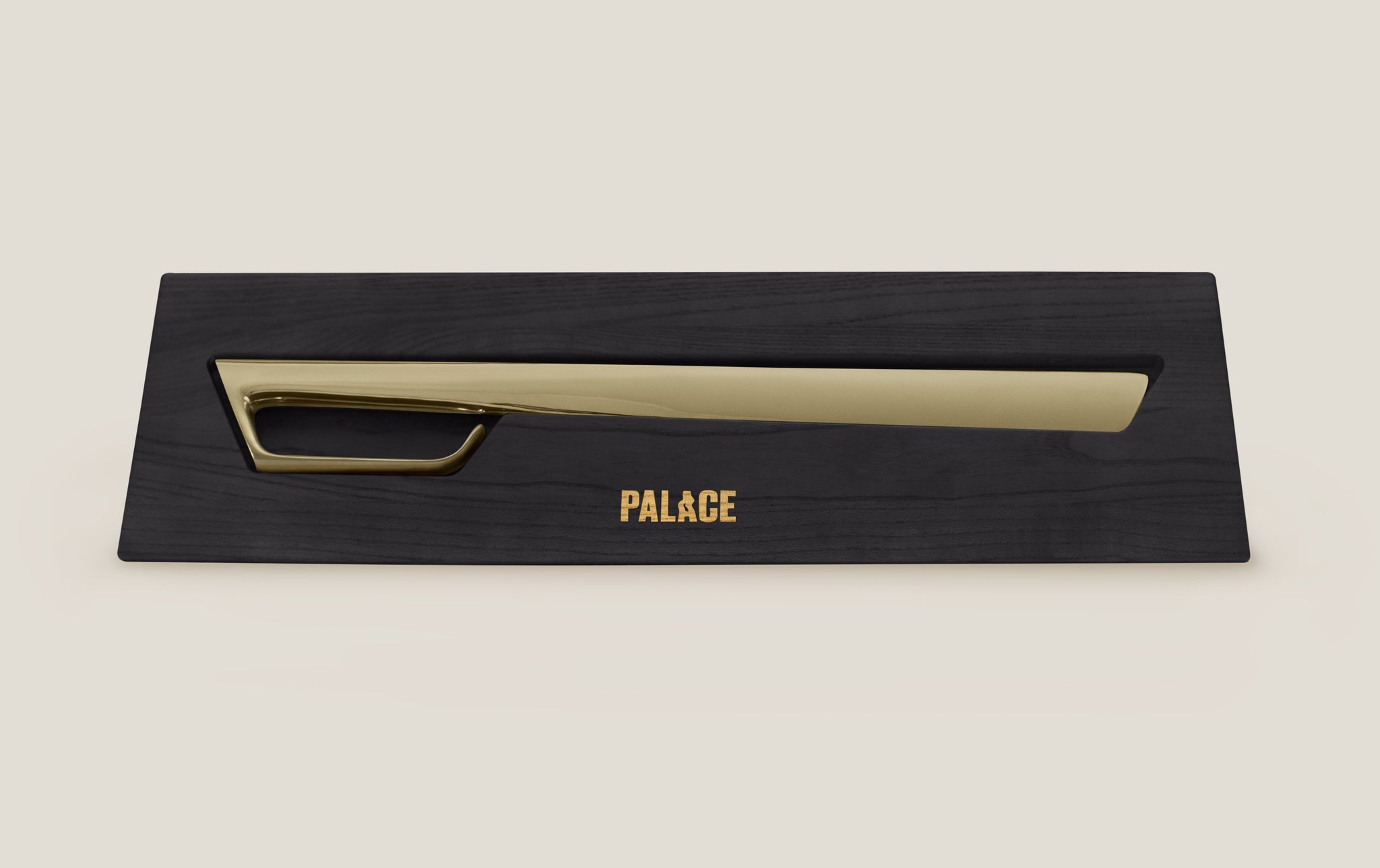 Gold champagne sabre in a black case laying on the ground