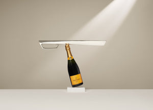 Champagne Sabre balanced precariously on a bottle of champagne